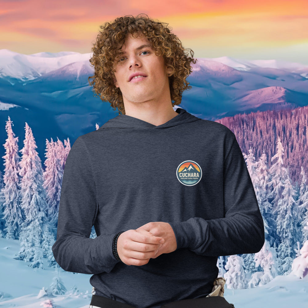 Person wearing a black hoodie with 'Cuchara Mountain Park' logo in a snowy mountain landscape. Person wearing a black hoodie with a logo against a snowy mountain landscape. lightweight long-sleeve hooded tee, unrestricted movement shirt, all-season layering top, comfortable athletic fit, stylish outdoor outfit, year-round trail essential, men's hooded t-shirt, cuchara mountain park hoodie, cuchara mountain park long sleeve shirt