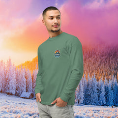 Man wearing a black long-sleeve shirt with a logo against a colorful winter landscape. Built for endurance. This unisex heavyweight long sleeve is garment-dyed for a rugged, lived-in look. Pre-shrunk fabric ensures maximum durable comfort on every expedition. Cuchara Mountain Park clothing, cuchara long sleeve shirt