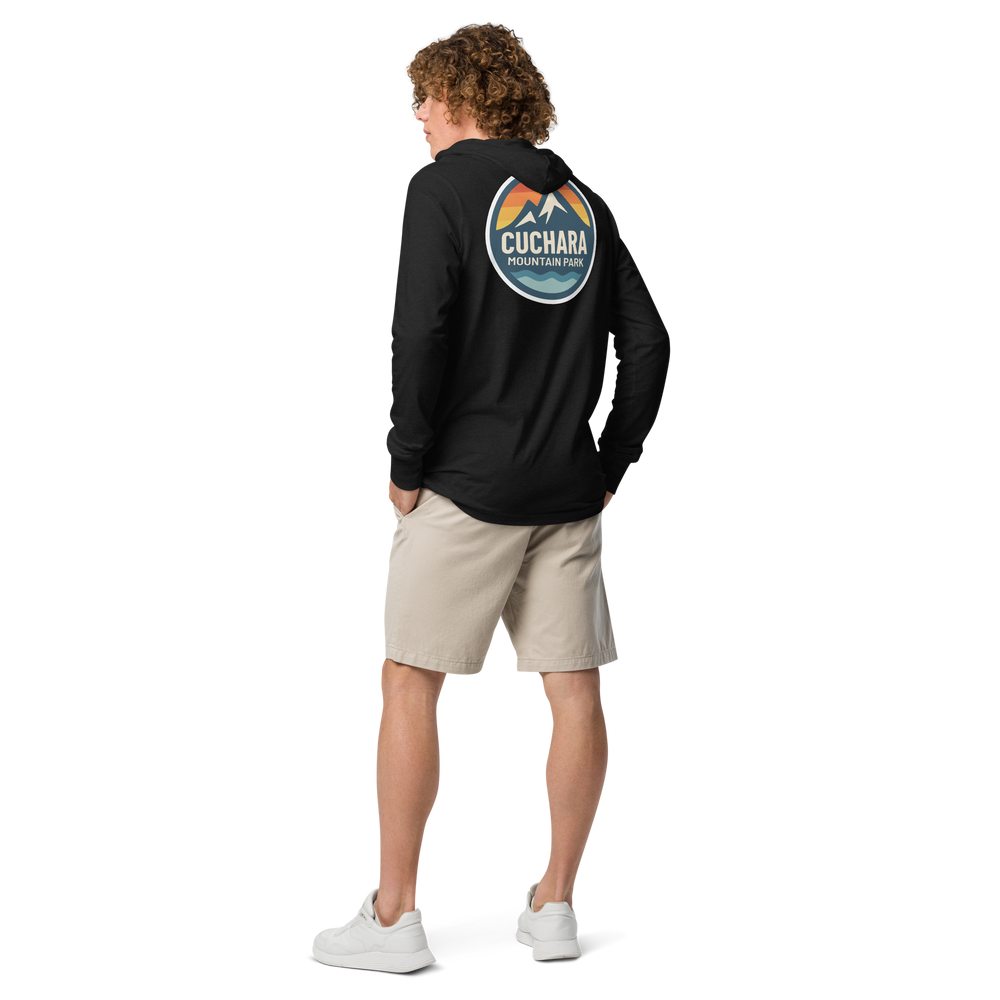 Person wearing a black hoodie with 'Cuchara Mountain Park' logo in a snowy mountain landscape. Person wearing a black hoodie with a logo against a snowy mountain landscape. lightweight long-sleeve hooded tee, unrestricted movement shirt, all-season layering top, comfortable athletic fit, stylish outdoor outfit, year-round trail essential, men's hooded t-shirt, cuchara mountain park hoodie, cuchara mountain park long sleeve shirt