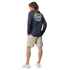 Person wearing a black hoodie with 'Cuchara Mountain Park' logo in a snowy mountain landscape. Person wearing a black hoodie with a logo against a snowy mountain landscape. lightweight long-sleeve hooded tee, unrestricted movement shirt, all-season layering top, comfortable athletic fit, stylish outdoor outfit, year-round trail essential, men's hooded t-shirt, cuchara mountain park hoodie, cuchara mountain park long sleeve shirt