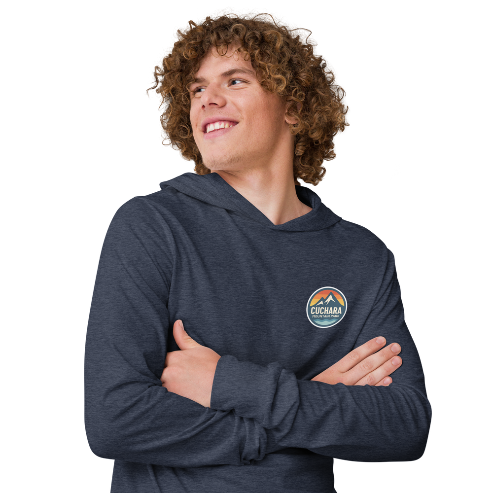 Person wearing a black hoodie with 'Cuchara Mountain Park' logo in a snowy mountain landscape. Person wearing a black hoodie with a logo against a snowy mountain landscape. lightweight long-sleeve hooded tee, unrestricted movement shirt, all-season layering top, comfortable athletic fit, stylish outdoor outfit, year-round trail essential, men's hooded t-shirt, cuchara mountain park hoodie, cuchara mountain park long sleeve shirt