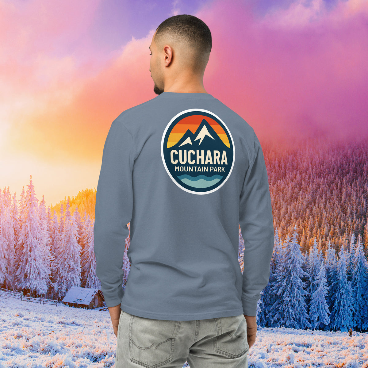 Man wearing a black long-sleeve shirt with a logo against a colorful winter landscape.  Built for endurance. This unisex heavyweight long sleeve is garment-dyed for a rugged, lived-in look. Pre-shrunk fabric ensures maximum durable comfort on every expedition. Cuchara Mountain Park clothing, cuchara long sleeve shirt