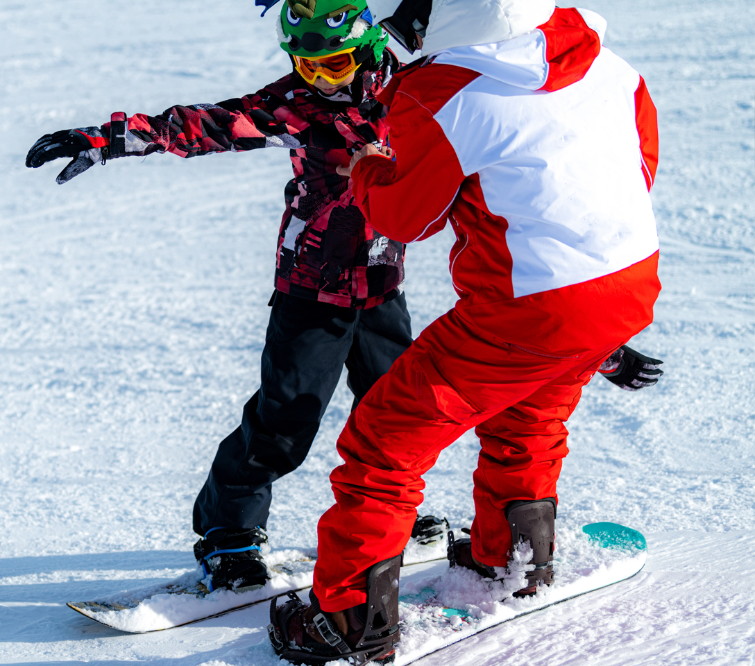 Two snowboarders on a snowy slope, one in red and white outfit, the other in colorful jacket and helmet.  Ski and Board Camp 2026, Cuchara Mountain Park, Colorado ski camp, Colorado snowboard camp, free ski camp Colorado, youth ski program Colorado, Huerfano County youth programs, Las Animas County youth programs, Outdoor Equity Grant, Colorado Parks and Wildlife youth programs, winter sports camp Colorado, kids ski lessons Colorado, youth snowboard lessons Colorado, free outdoor programs for kids, ski and 